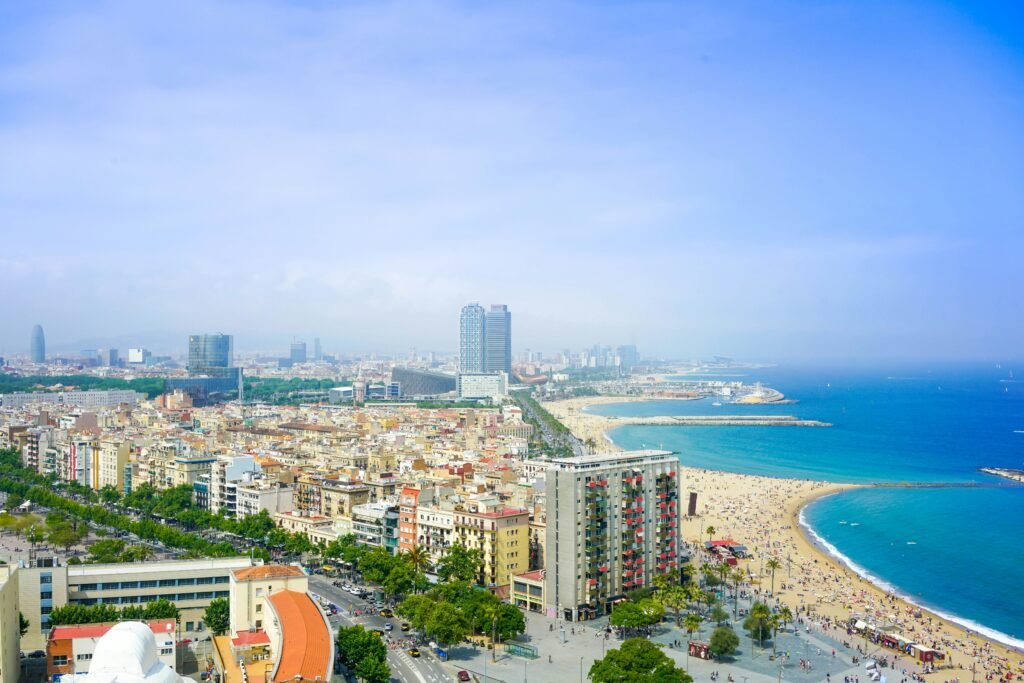 Coastal cityscape with beach and skyline. Barcelona, Spain. Photo by Enes on Unsplash